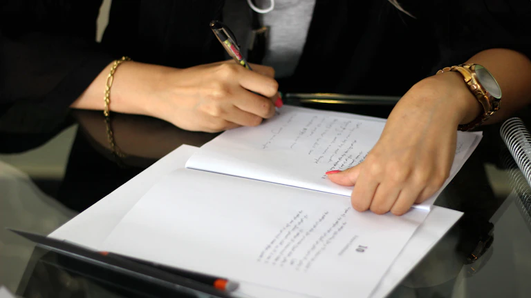 펜으로 서류에 서명하는 사람