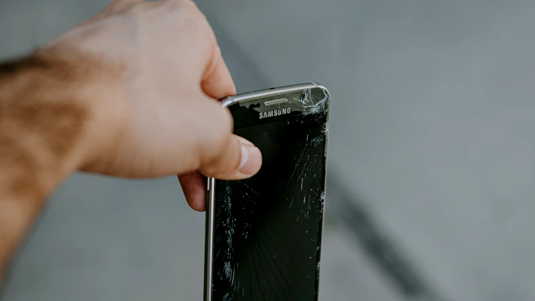 파손된 스마트폰을 들고 있는 손