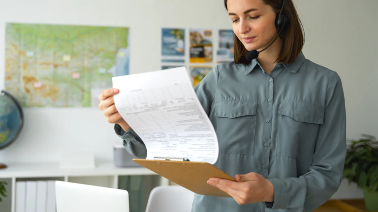 보험 증권을 돋보기로 자세히 살펴보는 사람