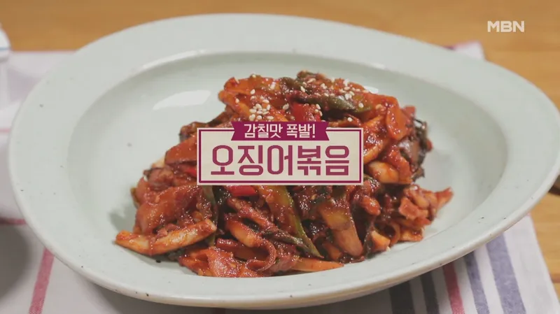 웍에서 빠르게 볶아지는 오징어와 채소